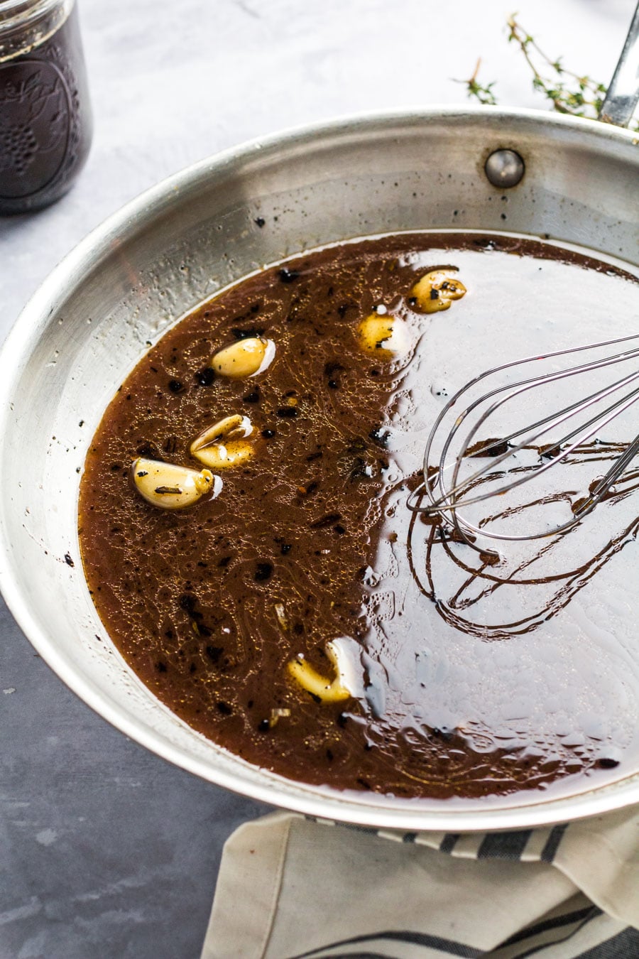 garlic cloves and au jus in a skillet with a whisk. 