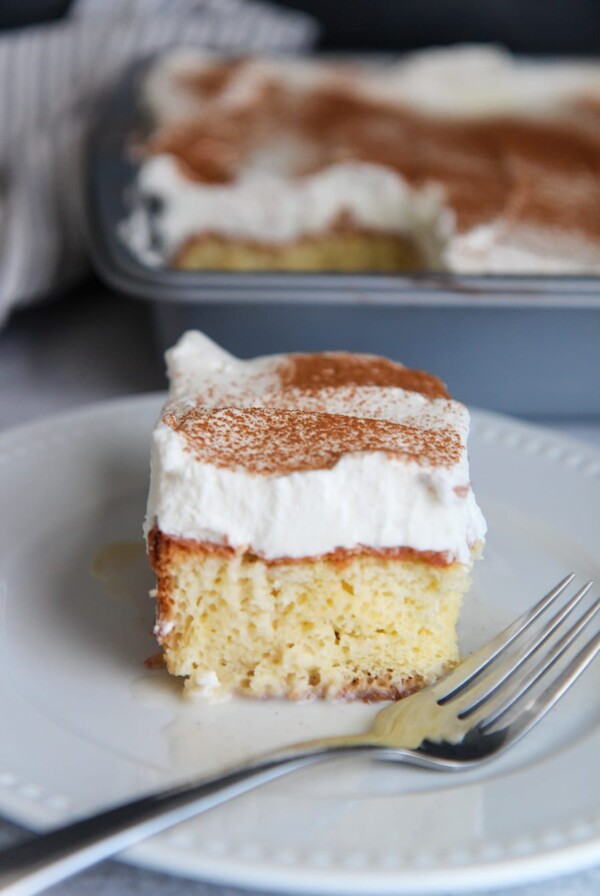 a slice of coquito cake up close with a fork on the side.