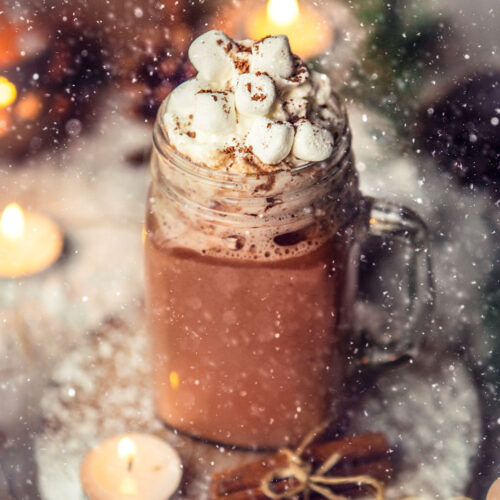 hot chocolate in a glass mug with marshmallows on top.