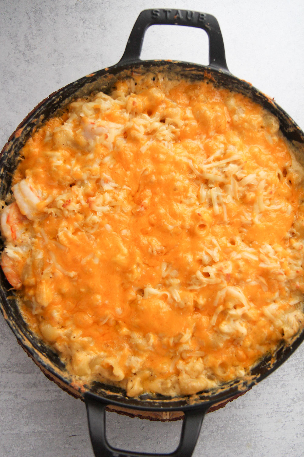 seafood macaroni and cheese in a black cast iron skillet. 