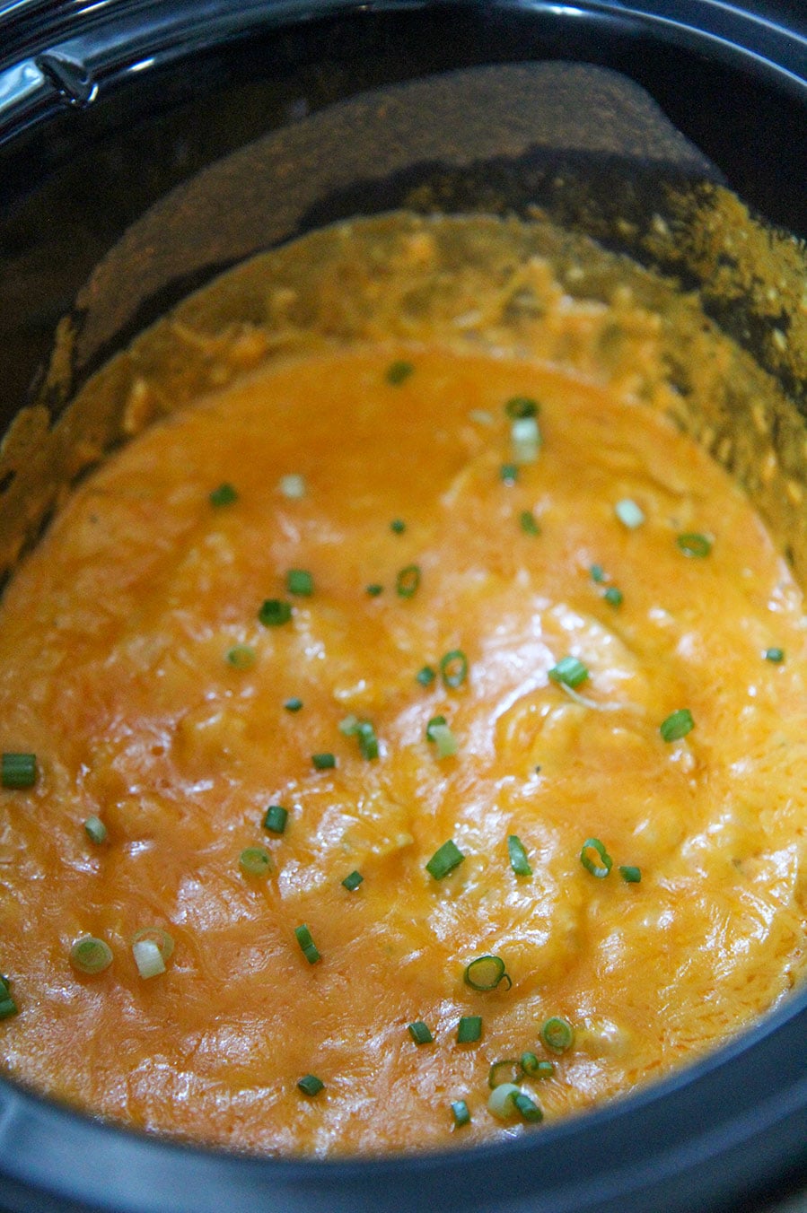 slow cooker buffalo chicken dip in a black crockpot