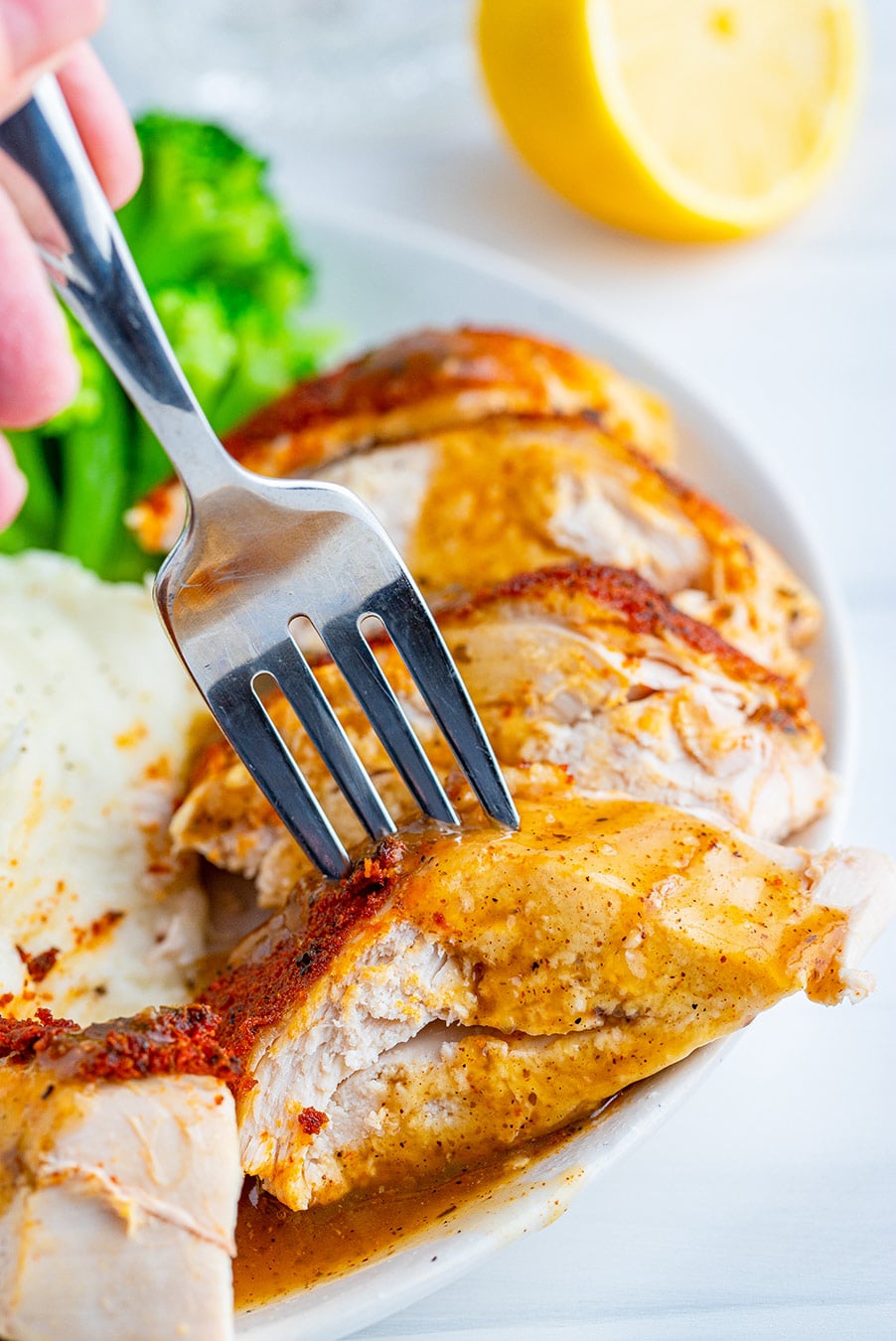 sliced chicken breast with a fork and gravy.