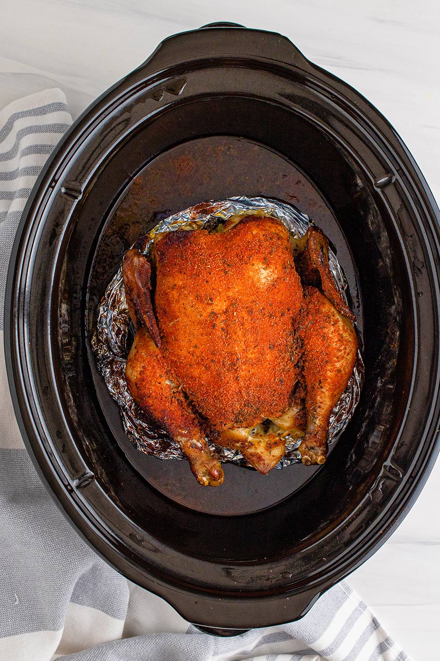 slow cooker whole chicken on top of aluminum foil. 