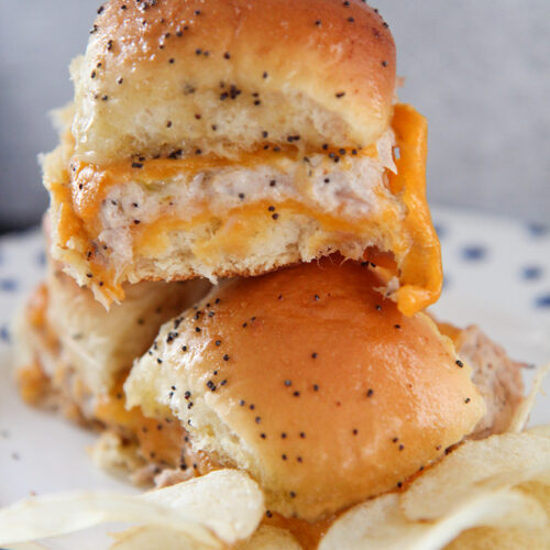 three hot tuna melt sliders with chips on a plate.