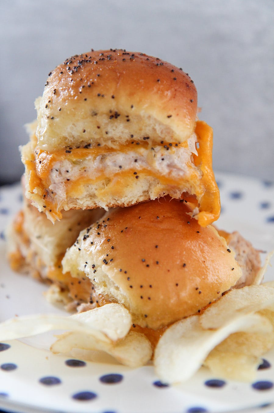 three hot tuna melt sliders with chips on a plate.