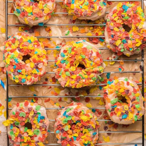 8 fruity pebble donuts on a wire rack