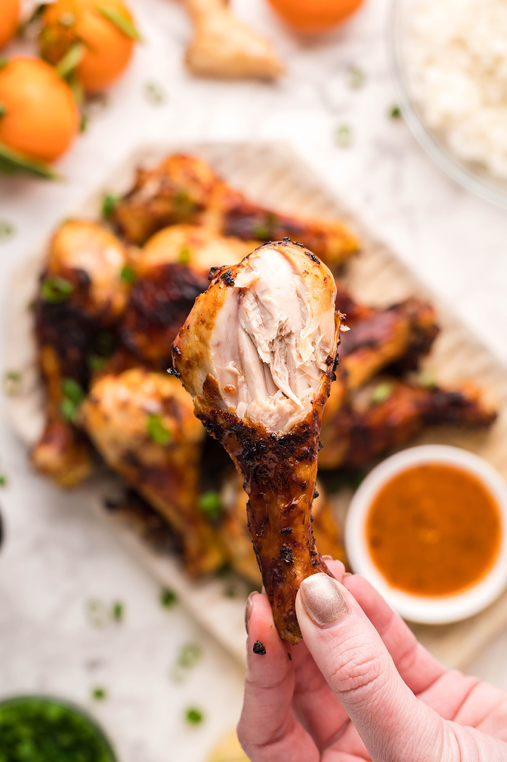 hand holding bitten chicken drumstick.