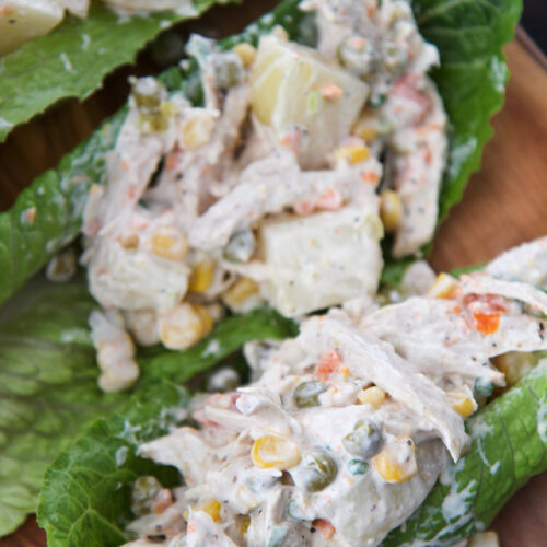 ensalada de pollo (chicken salad) on three lettuce cups.