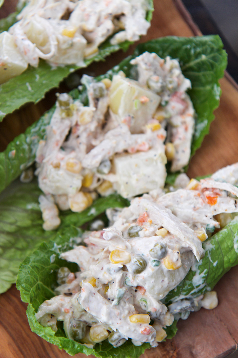 ensalada de pollo (chicken salad) on three lettuce cups.