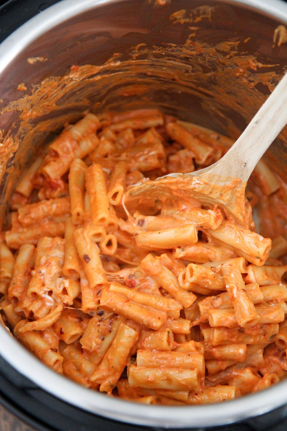 baked ziti in the instant pot with a wooden spoon