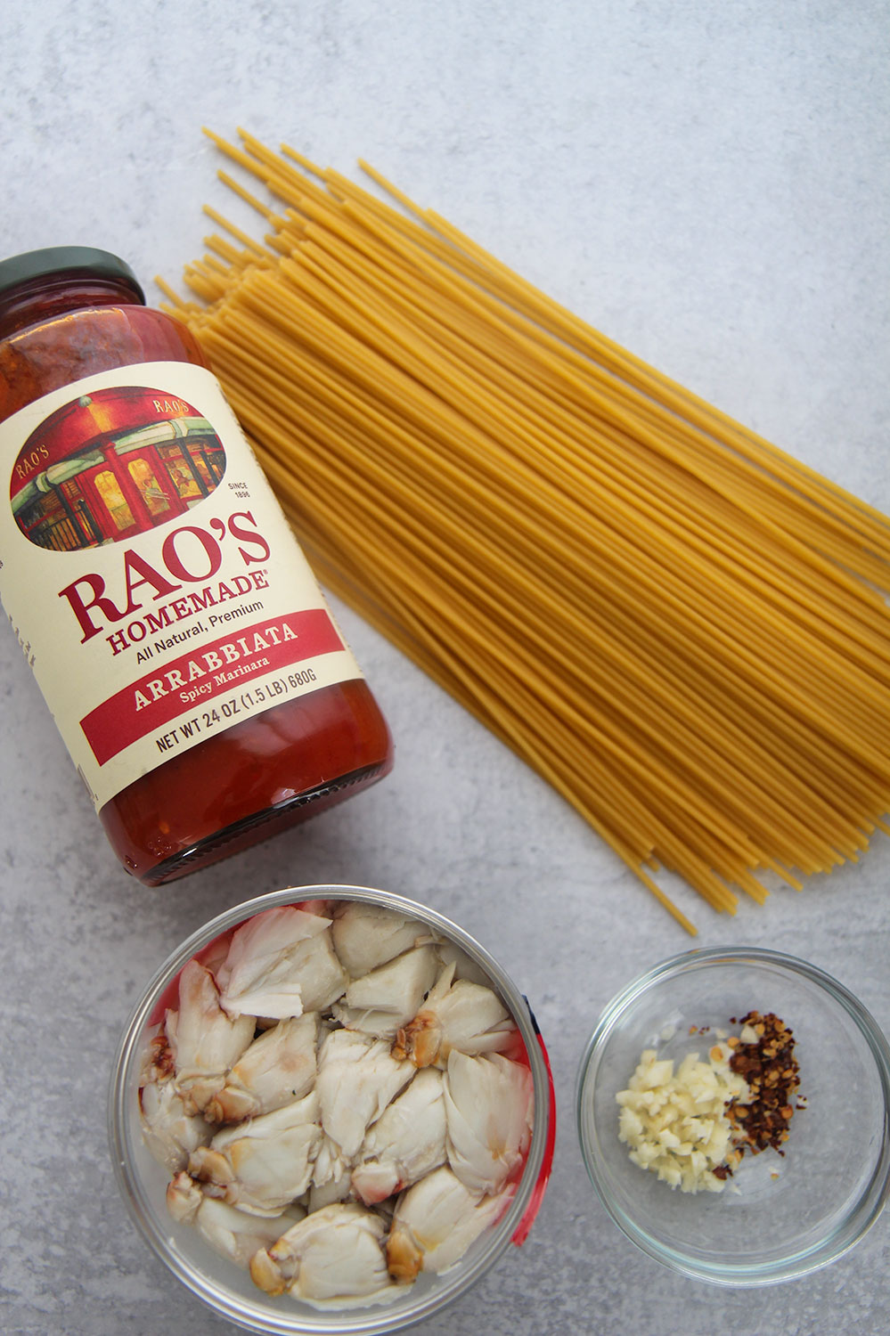 sauce in a jar, bucatini pasta, crab meat, and garlic and red crushed pepper in a small bowl. 