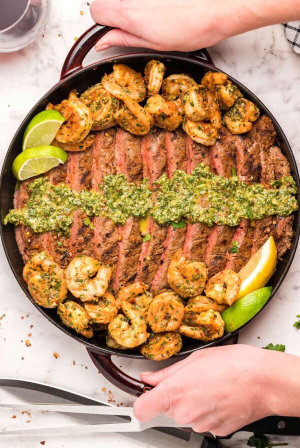 steak, shrimp, and chimichurri, on a grill.
