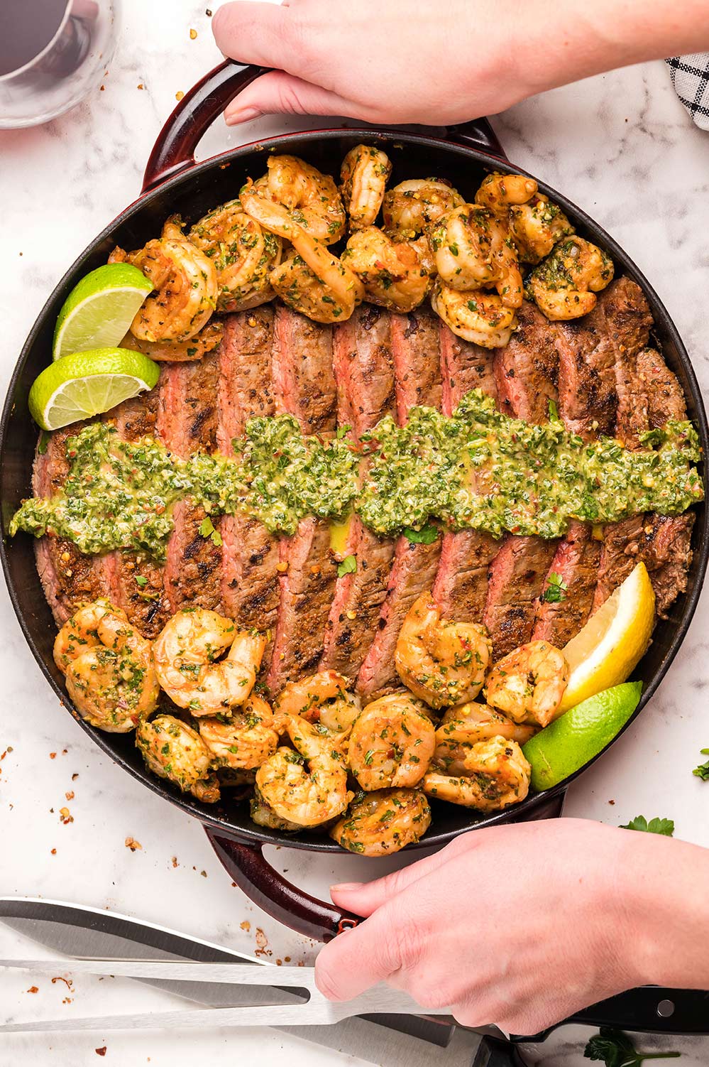 steak, shrimp, and chimichurri, on a grill. 