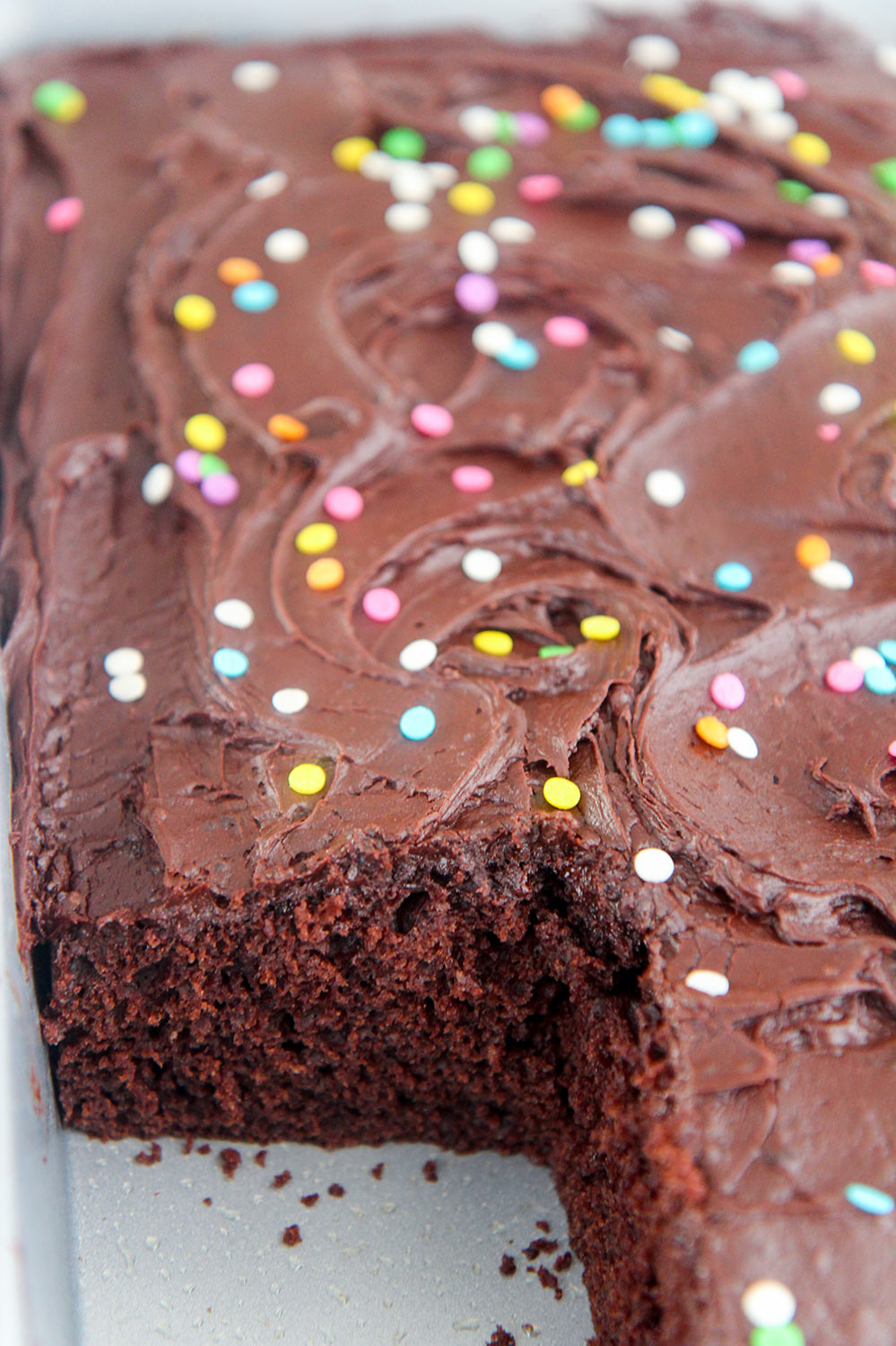 buttermilk chocolate cake in a baking dish with a slice missing. 