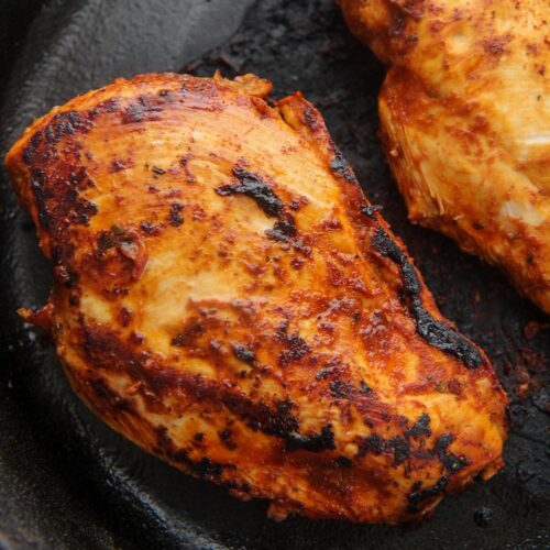 two chipotle chicken breasts in a cast iron skillet.