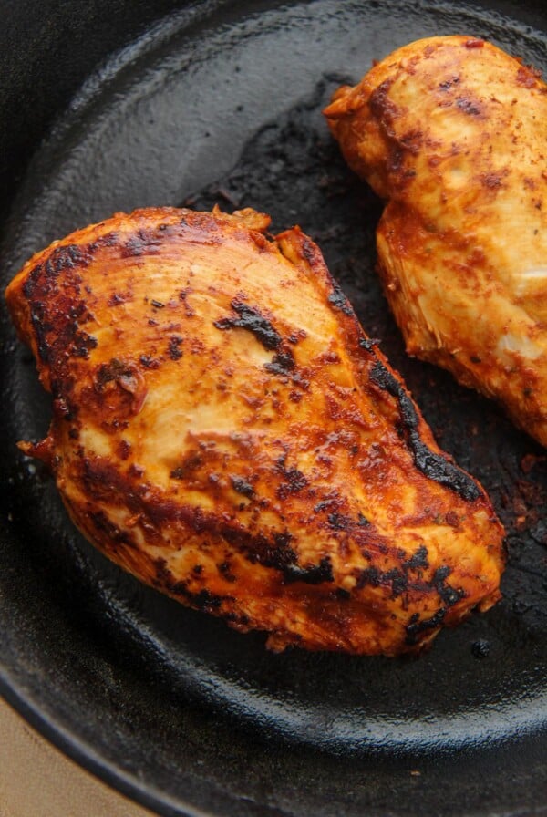 two chipotle chicken breasts in a cast iron skillet.
