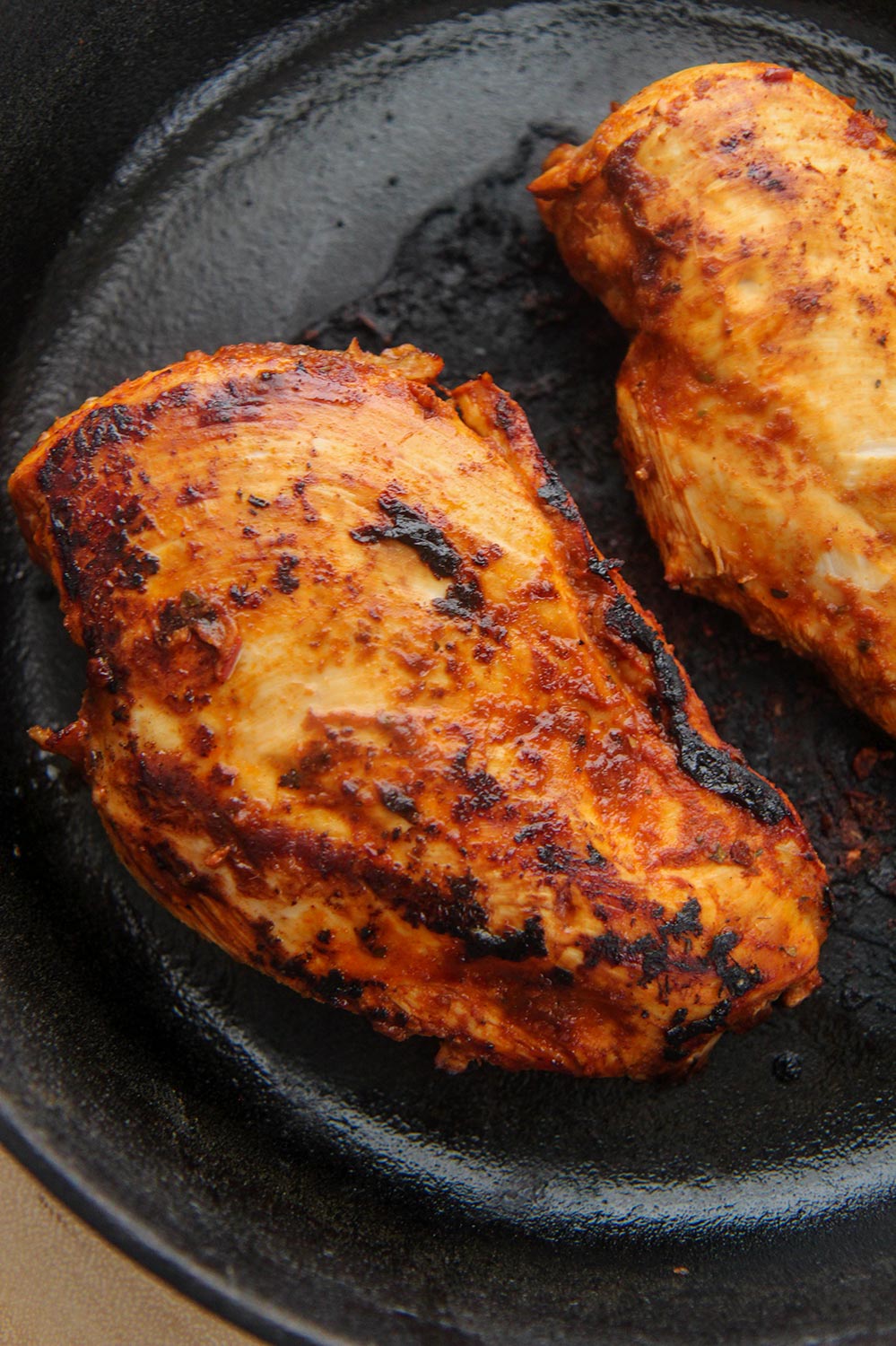 two chipotle chicken breasts in a cast iron skillet.