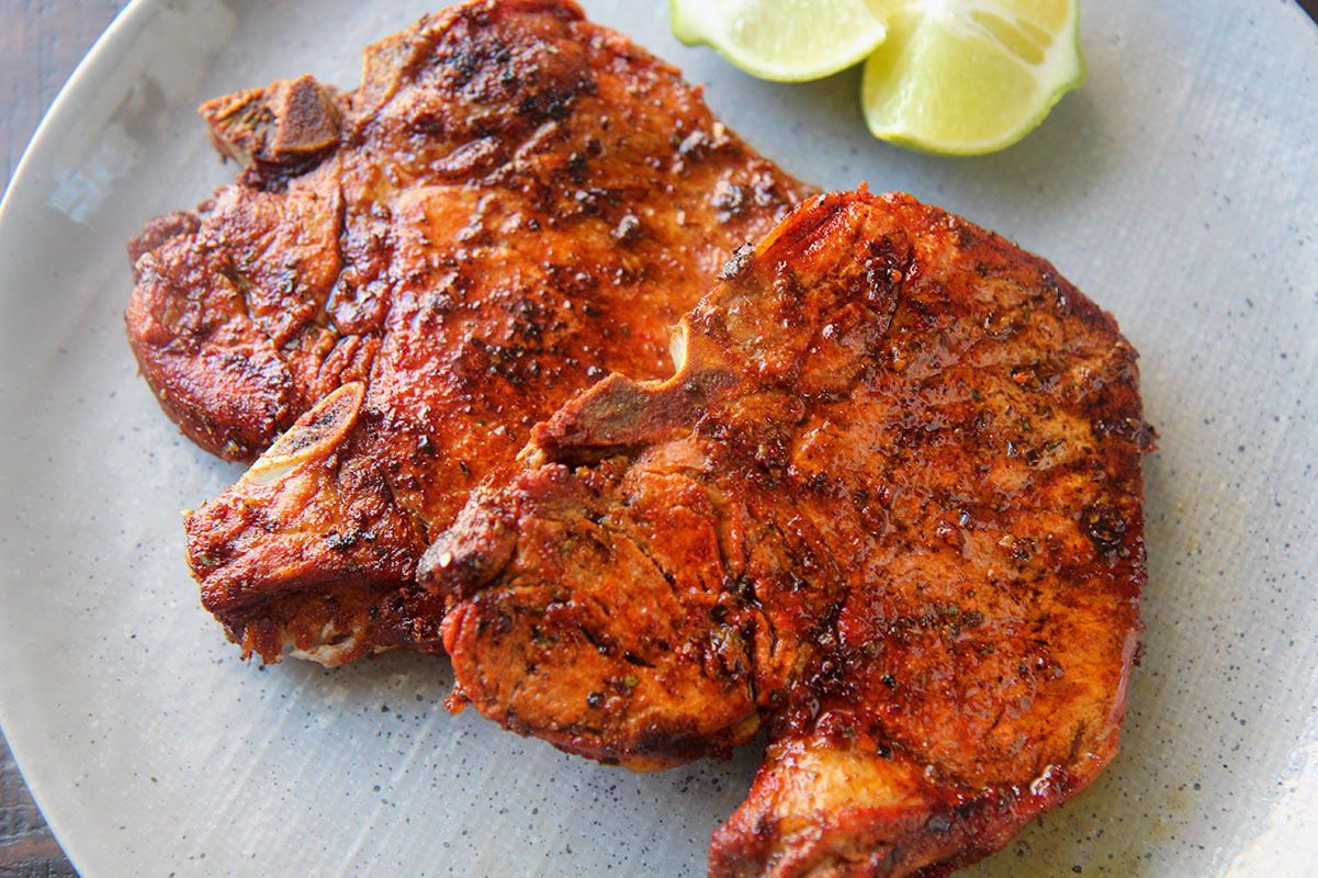 two fried pork chops up close. 