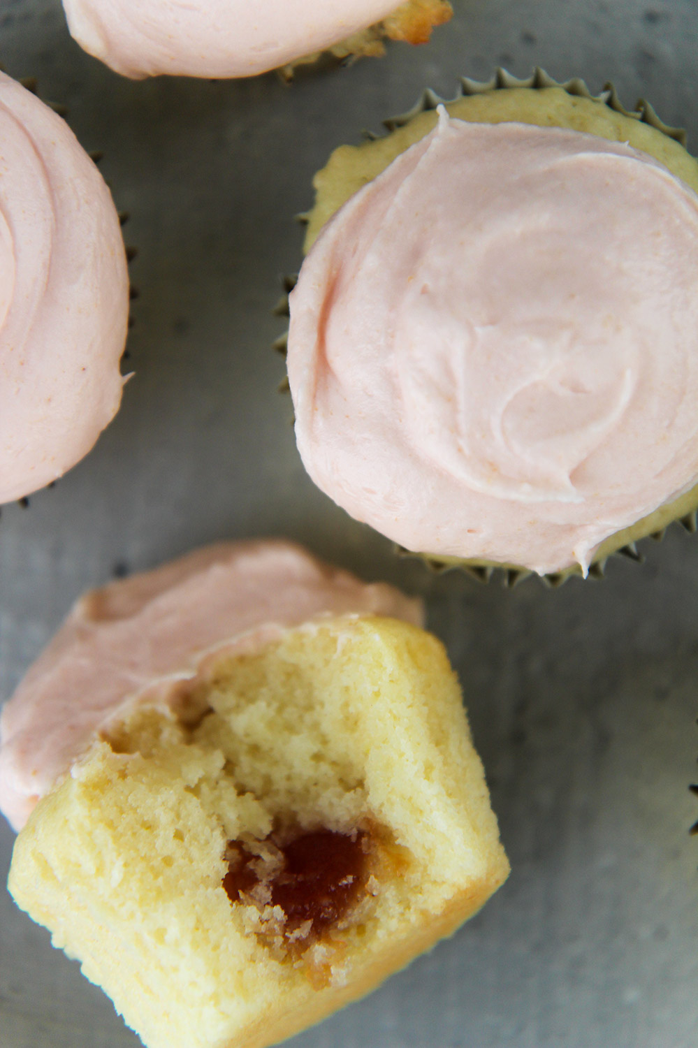 4 guava cupcakes with frosting on top