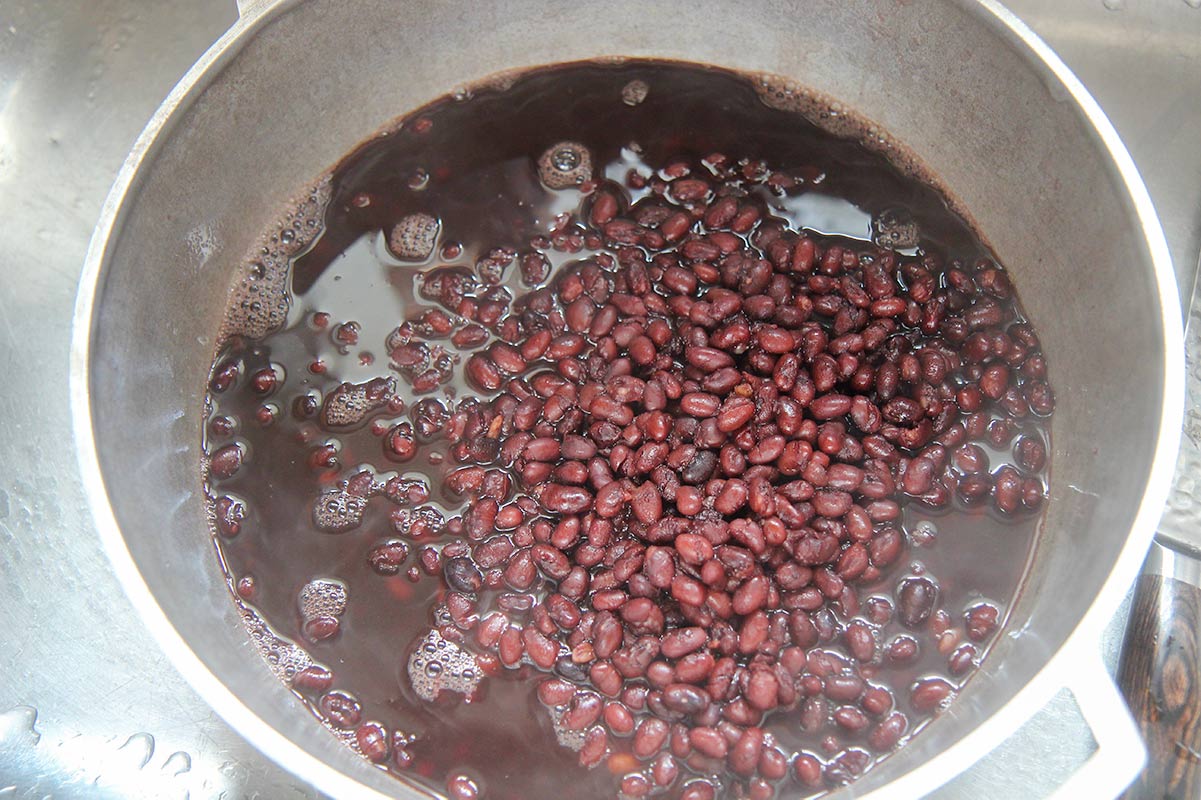 cooked black beans and liquid in a pot.