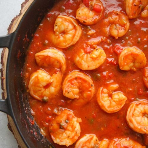 Cuban shrimp creole (enchilado de camarones) with red sauce in a black skillet up close.