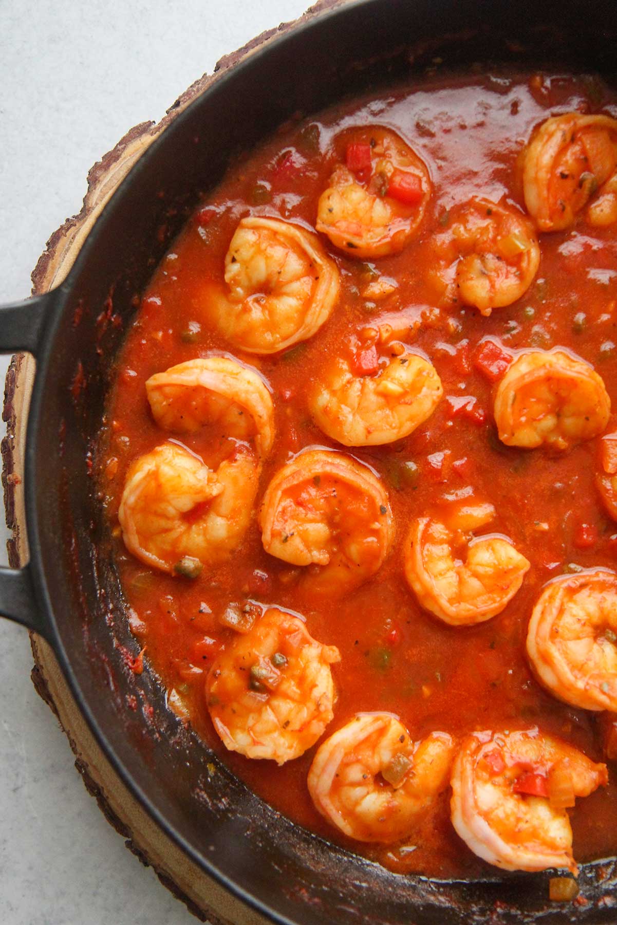 Cuban shrimp creole (enchilado de camarones) with red sauce in a black skillet up close.