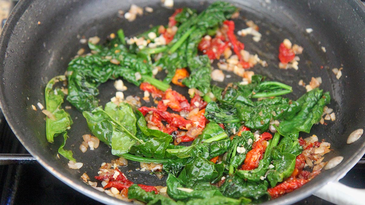 spinach, onions, garlic, and sun dried tomatoes in a skillet. 
