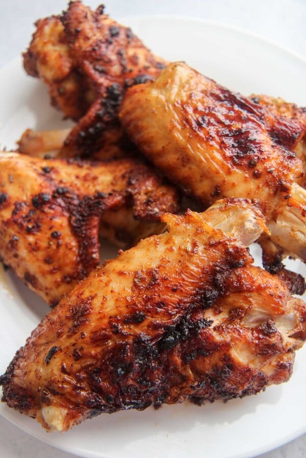 4 air fried turkey wings on a white plate.