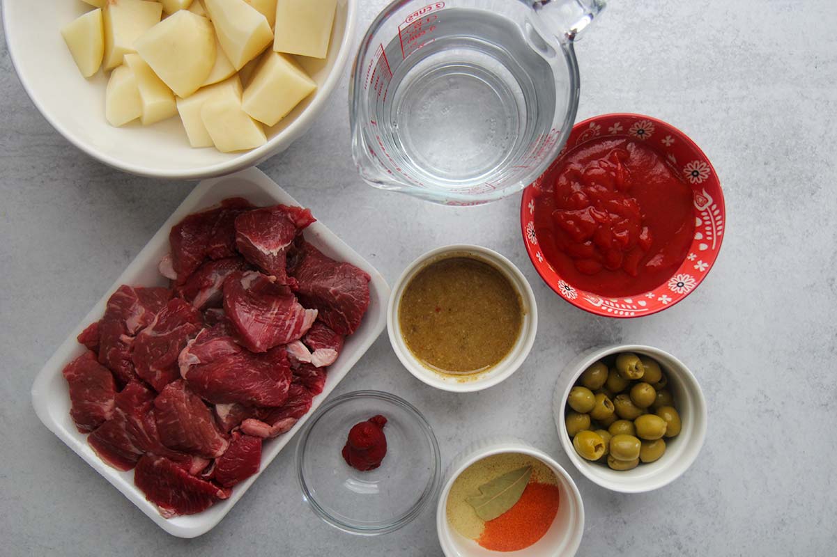 raw beef chunks, tomato sauce, olives, potatoes, spices, sofrito, and water. 