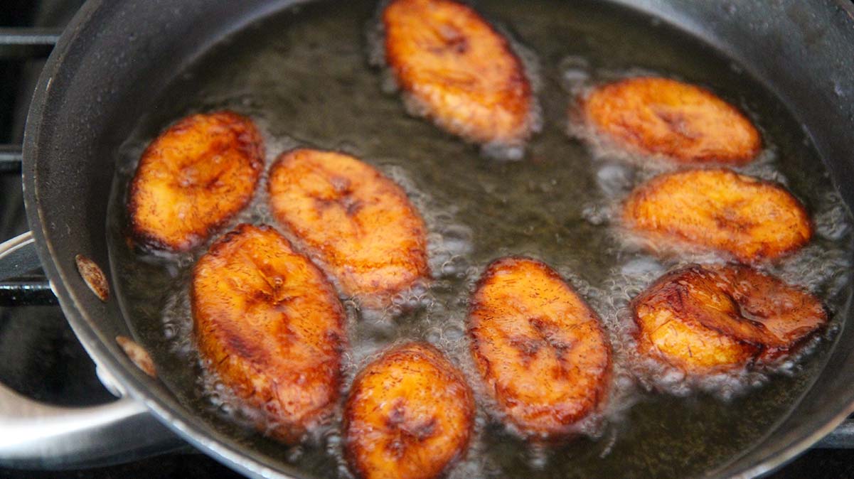 9 caramelized sweet plantains frying in oil. 