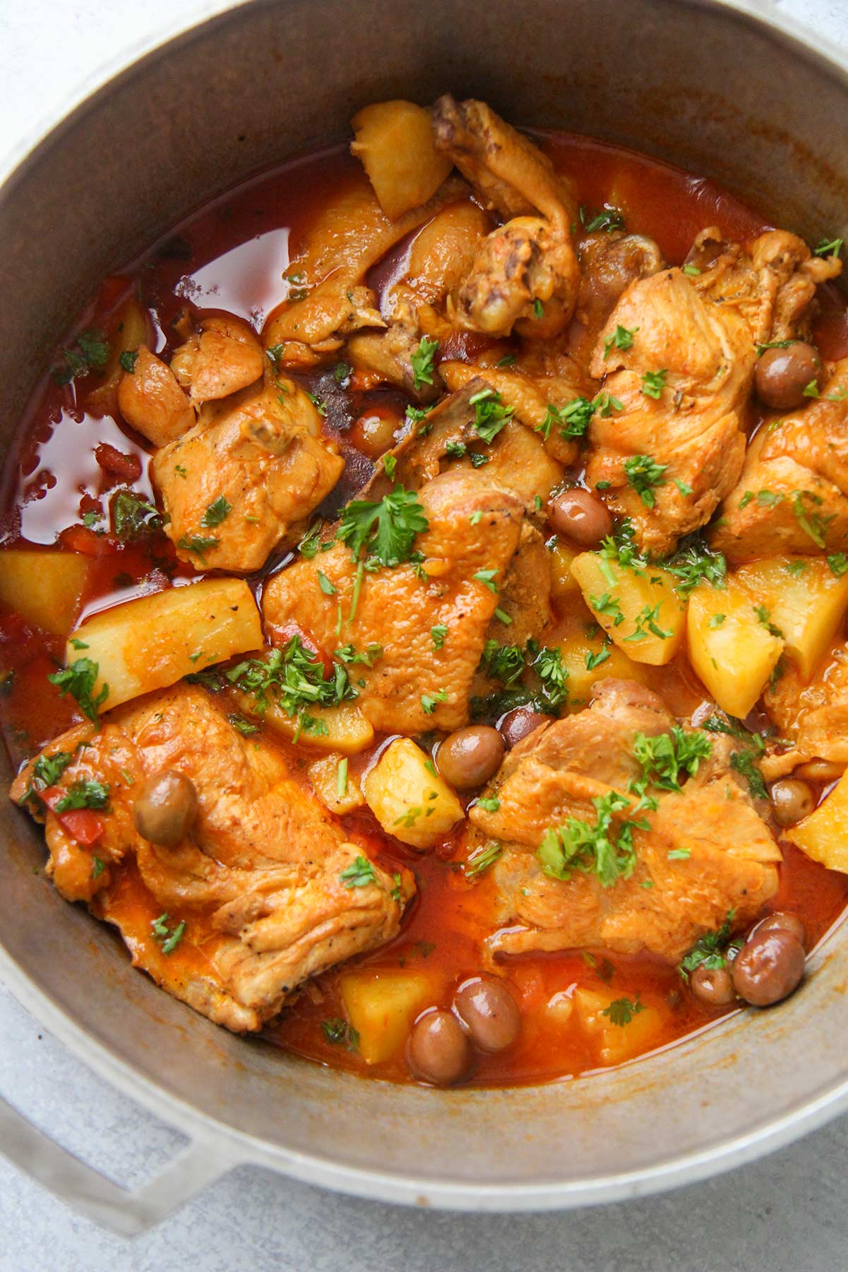 Pollo guisado (chicken stew) in a large pot up close. 
