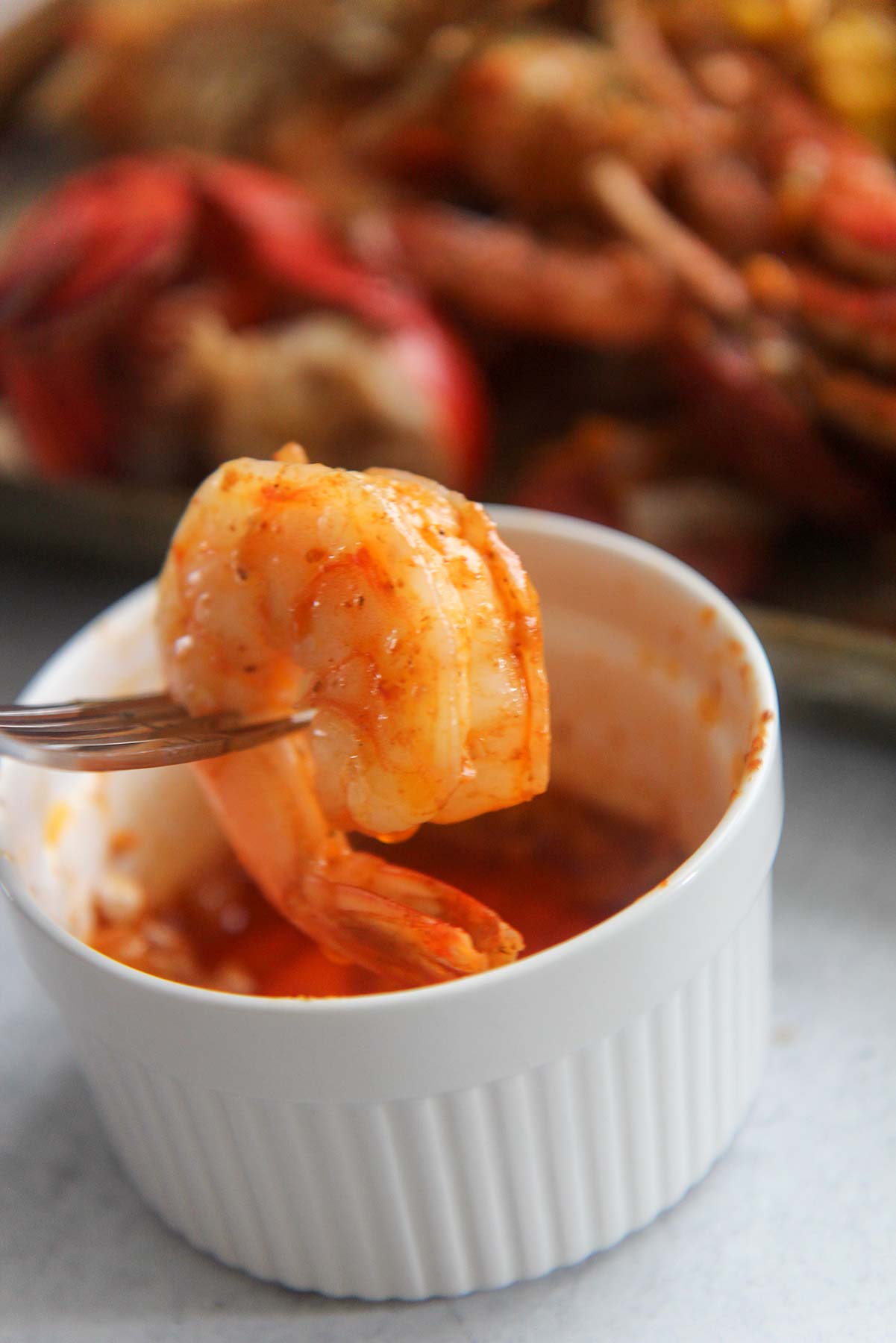 Shrimp dipped in seafood boil sauce. 