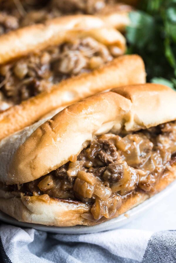 Two Philly cheesesteak sandwiches up close.