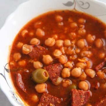 Garbanzos guisados in a white bowl up close.