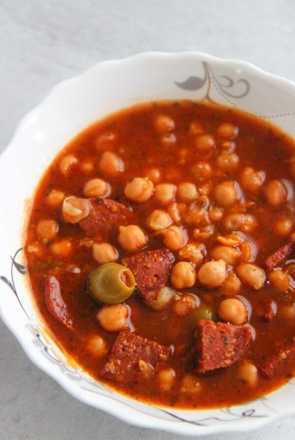 Garbanzos guisados in a white bowl up close.