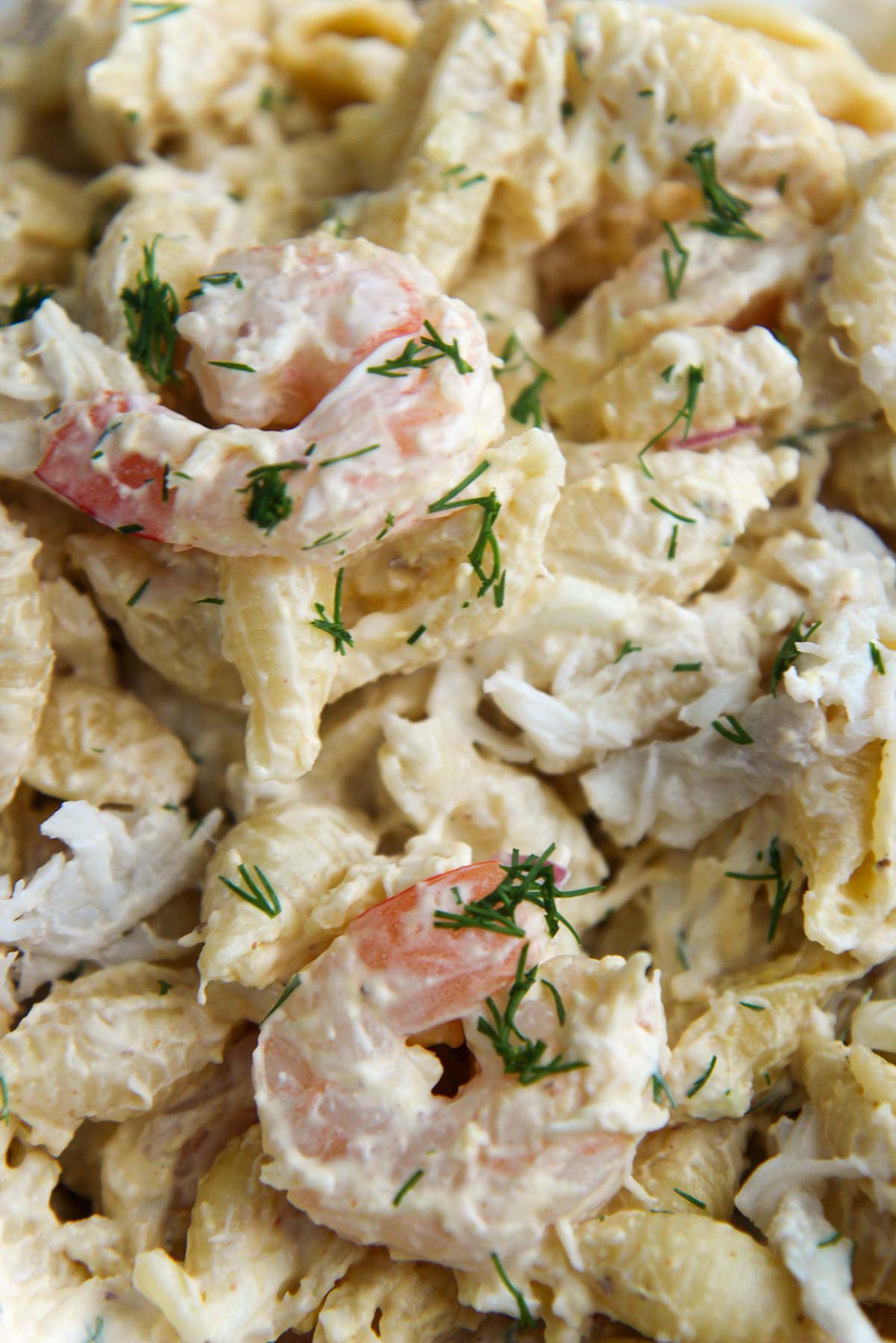 pasta salad up close with shrimp and crab on top. 