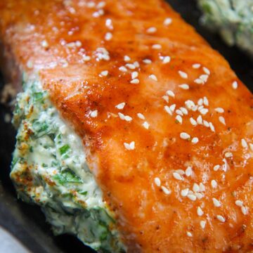 spinach stuffed salmon in a cast iron skillet.