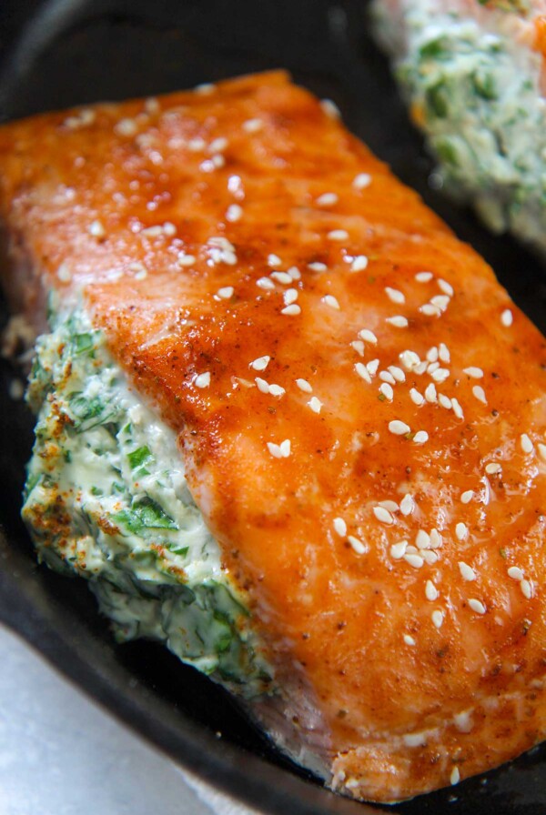 spinach stuffed salmon in a cast iron skillet.