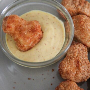 frozen chicken nuggets with honey mustard on the side.