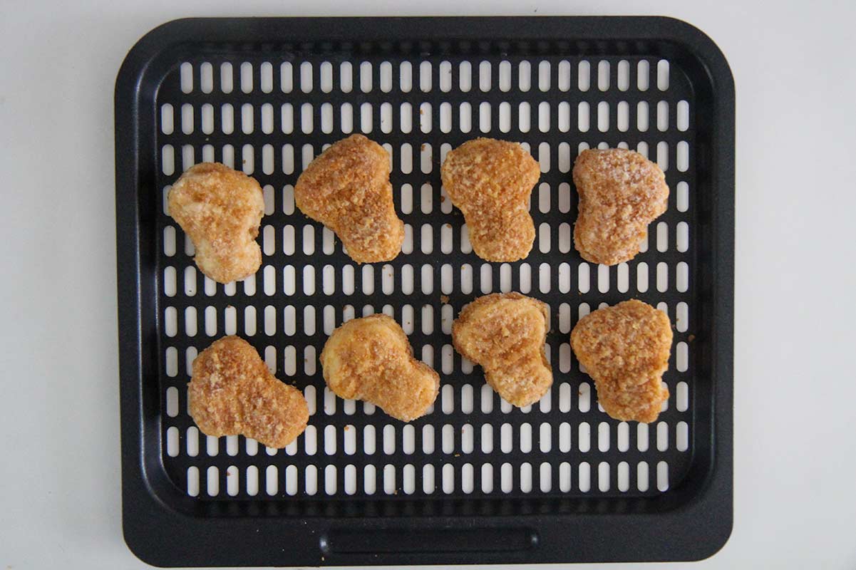 frozen chicken nuggets on the air fryer tray. 