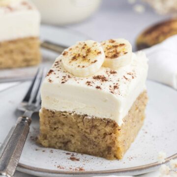 a slice of moist banana cake with a fork on the side.