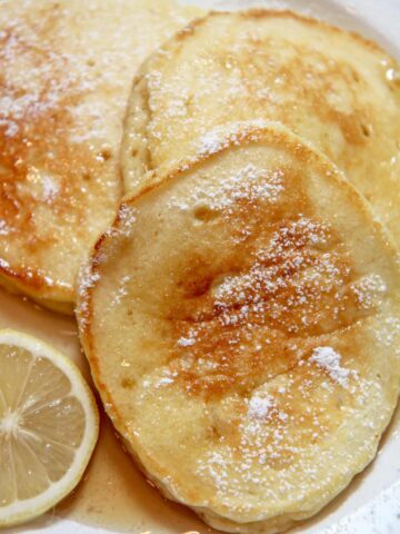 lemon ricotta pancakes with syrup and lemon slices