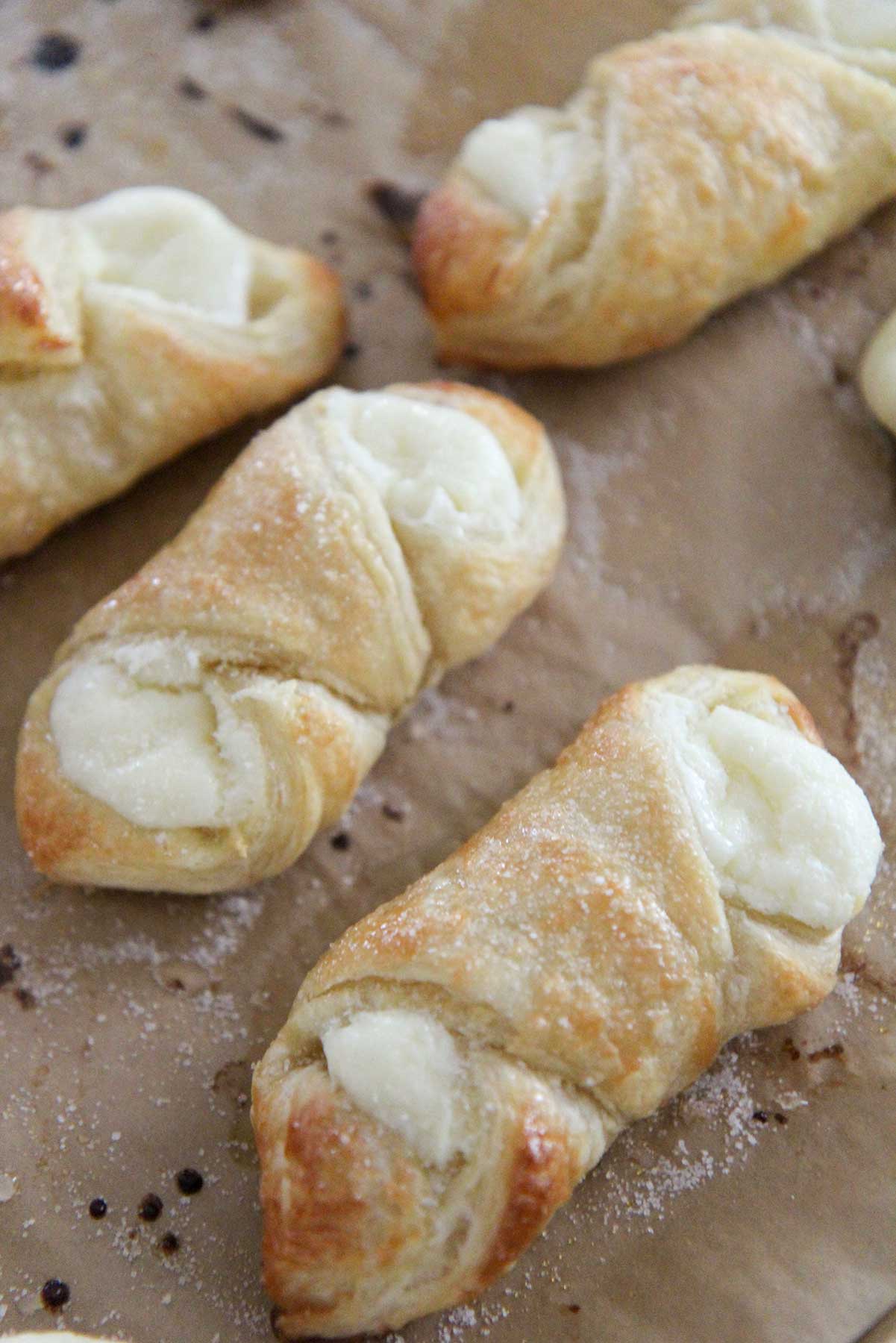 baked cream cheese filled pastries on a baking sheet. 