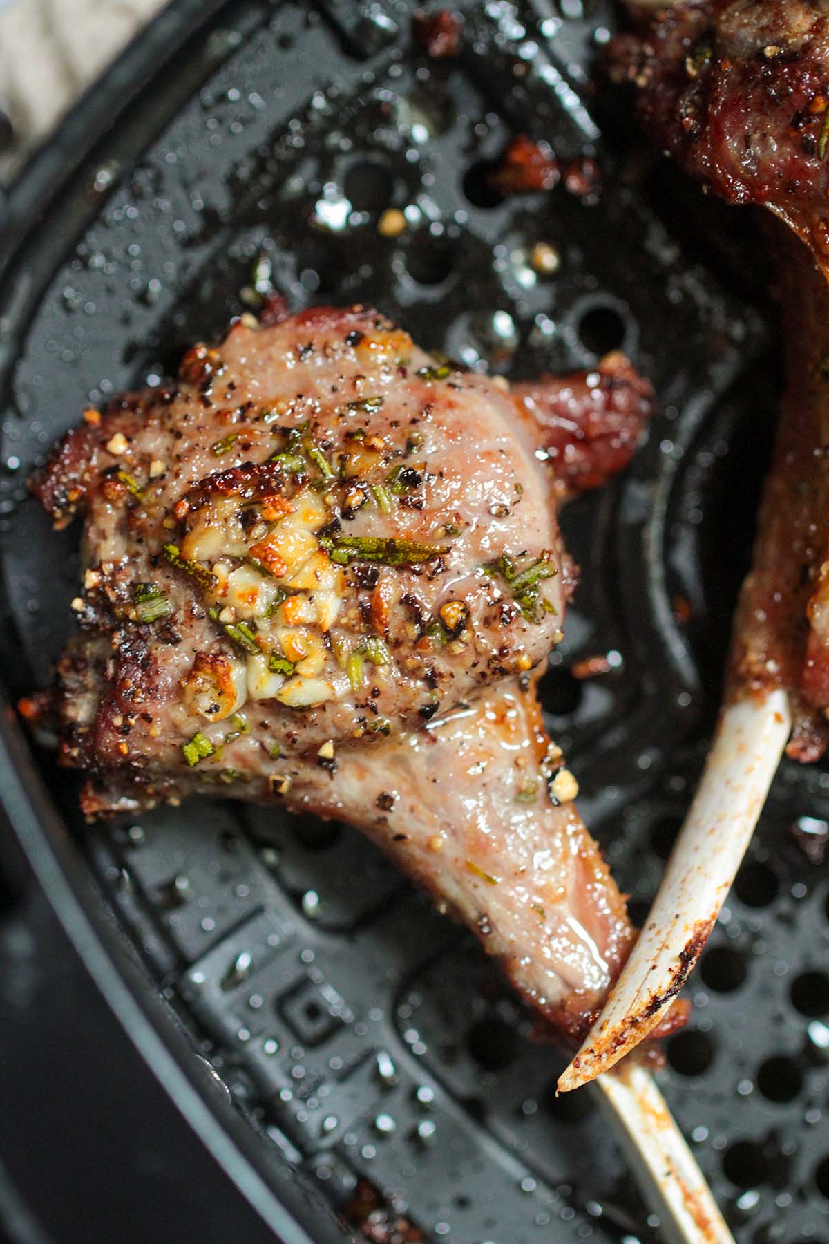 cooked lamb chops in the air fryer basket.