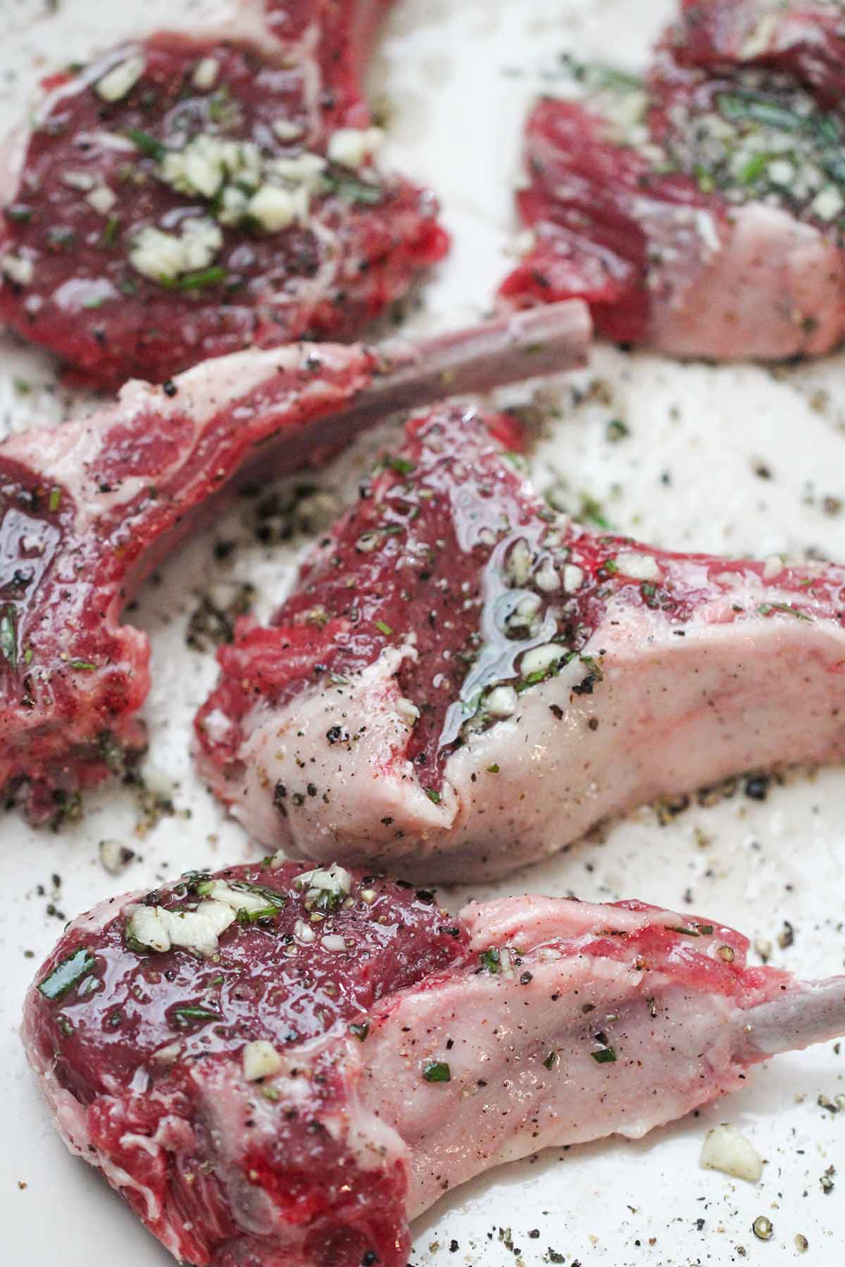 raw lamb chops with oil, garlic, and rosemary. 