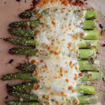 cheesy garlic asparagus on a baking sheet.