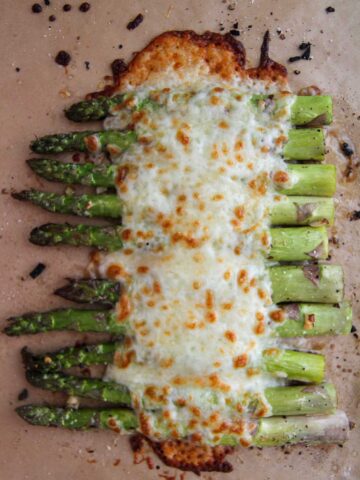 cheesy garlic asparagus on a baking sheet.