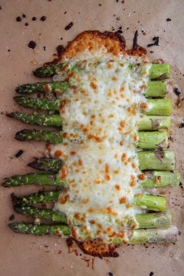 cheesy garlic asparagus on a baking sheet.