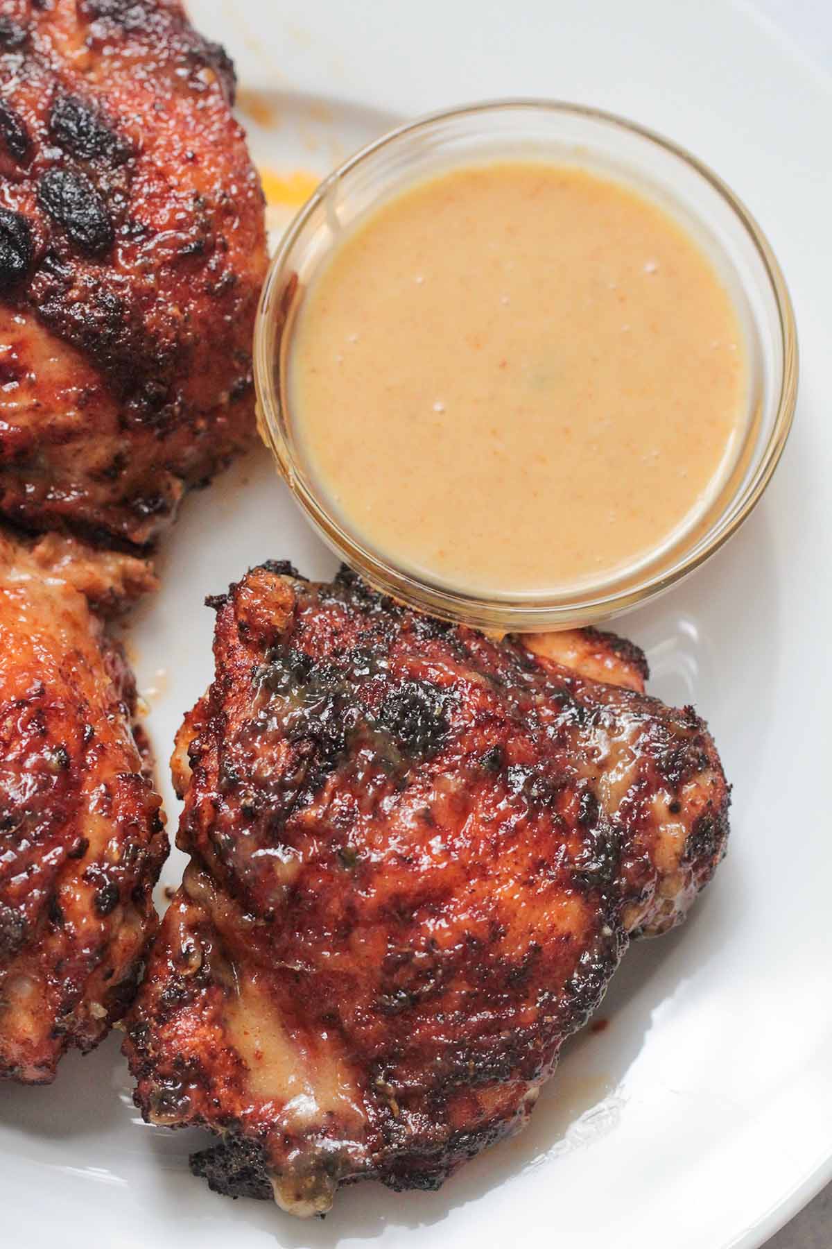 air fryer chicken thighs on a plate with a side of honey mustard.