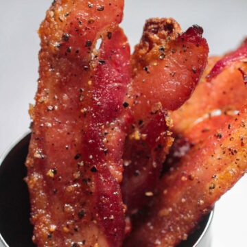 candied bacon strips in a cup.